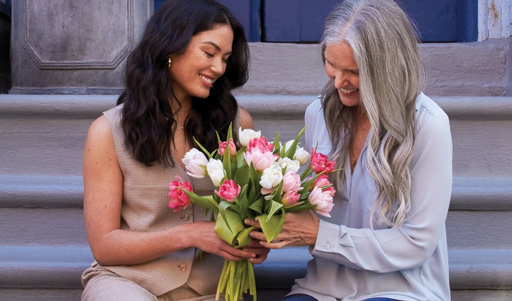A Mother receiving a bouquet of tulips from her daughter