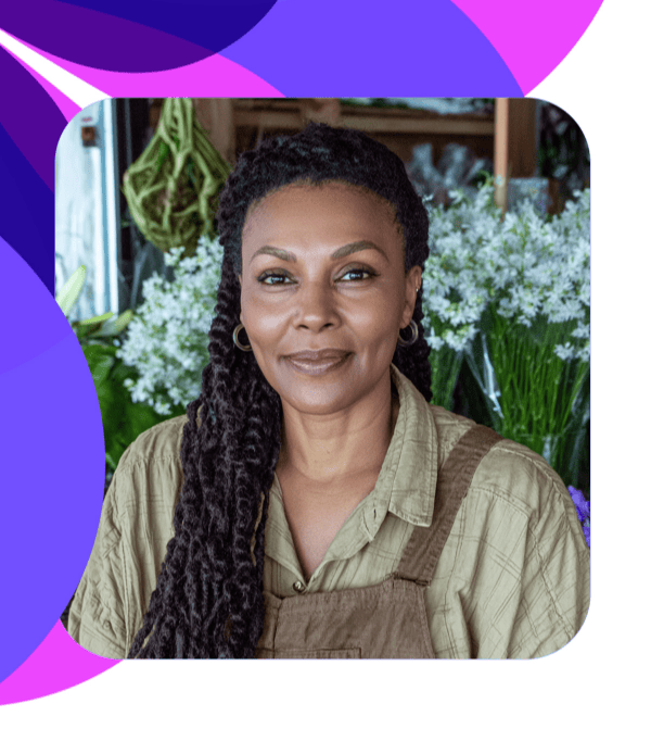 portrait of florist in her shop smiling, facing camera.